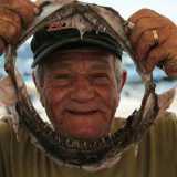 Il pescatore Oronzo Lagioia mentre gioca con le fauci di uno squalo